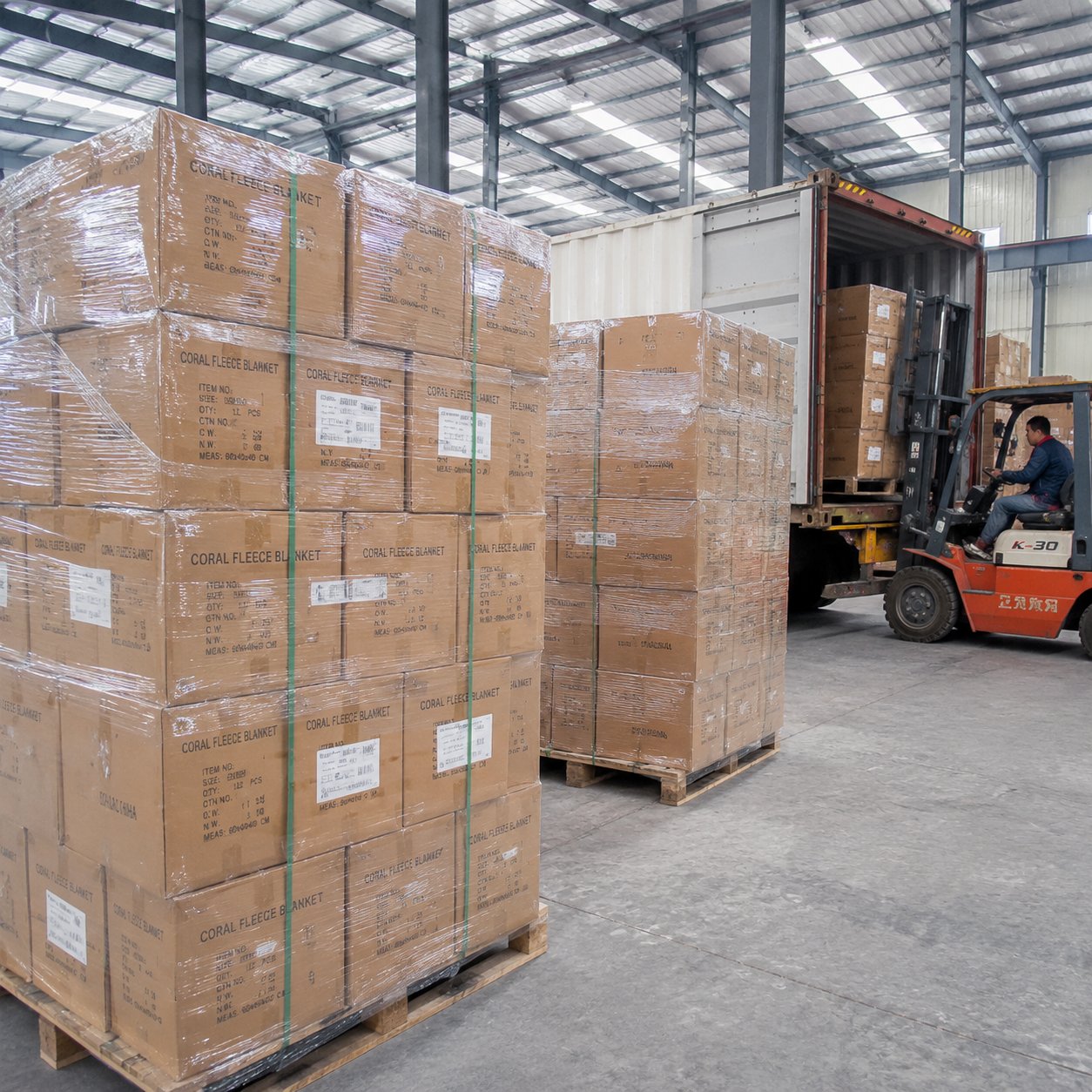 Pallets of cartons of finished blankets ready for export shipping in a factory warehouse